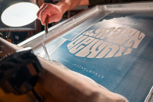 Auffüllen von Siebdruckfarbe auf ein Sieb während des Druckens