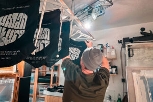 Chris beim Aufhängen der bedruckten Turnbeutel